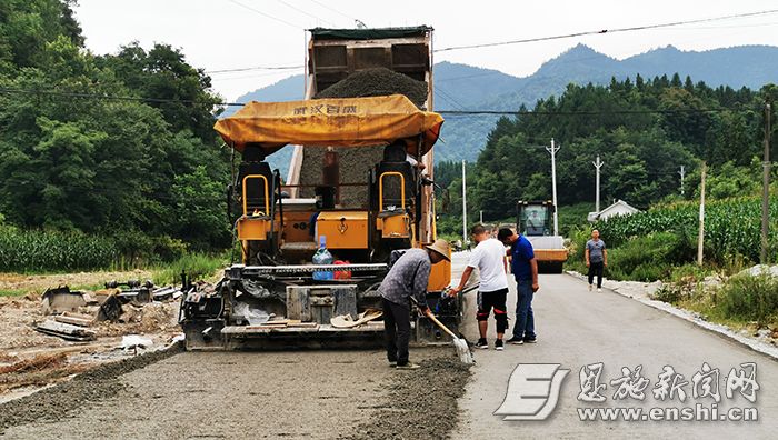 在350国道利川市凉雾集镇改线工程建设工地,工人们正忙着铺设水稳层.