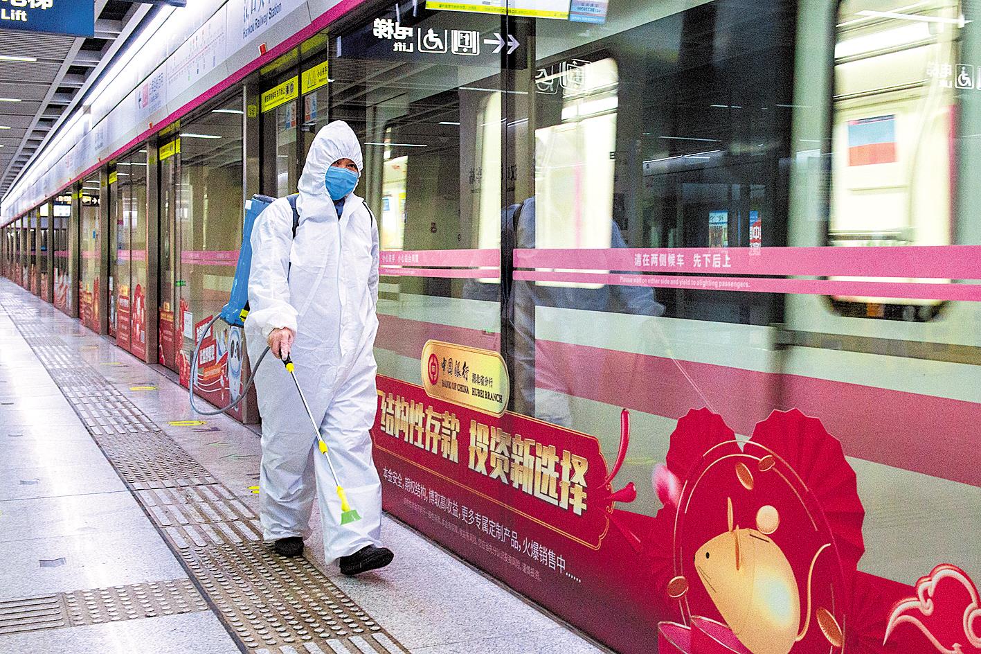 图为汉口火车站地铁站工作人员对站台进行消毒.