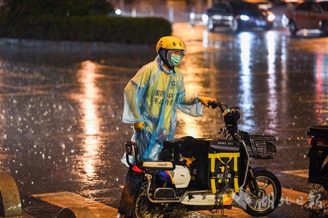 武汉快递小哥风雨中奔忙