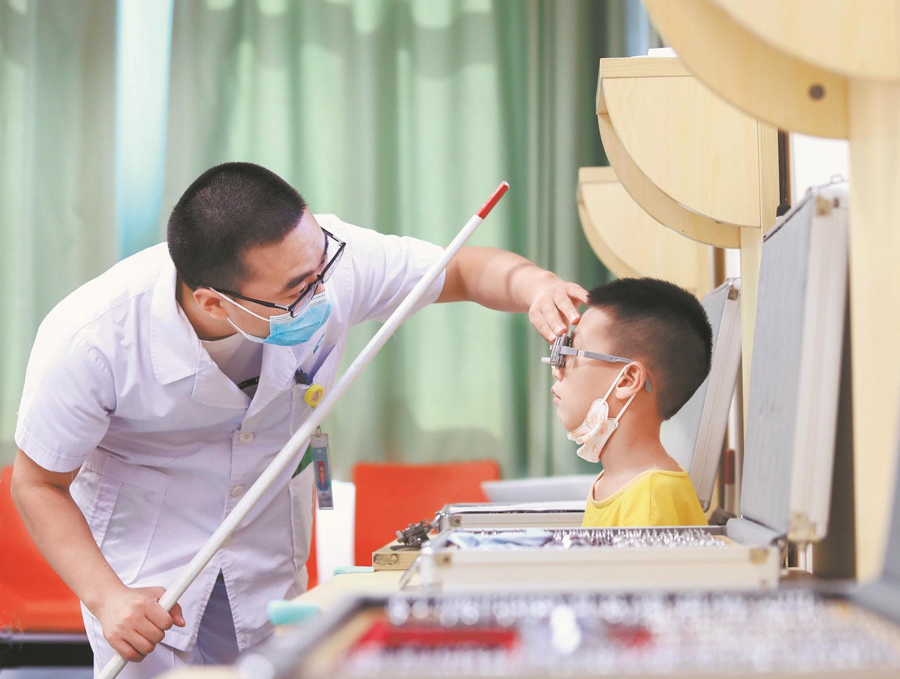 武汉儿童医院眼科医生为孩子检查视力
