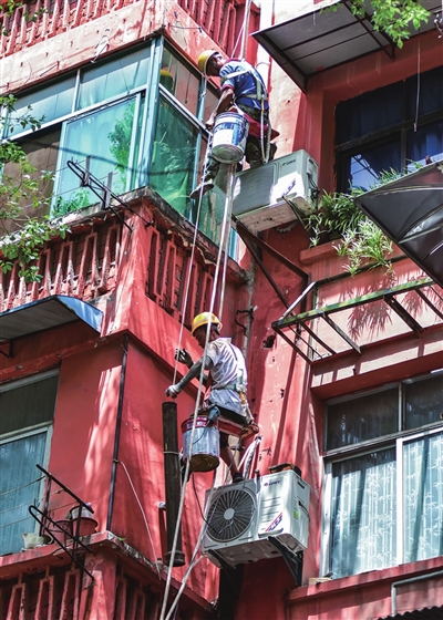 工人在九龙洞社区粉刷楼房外墙