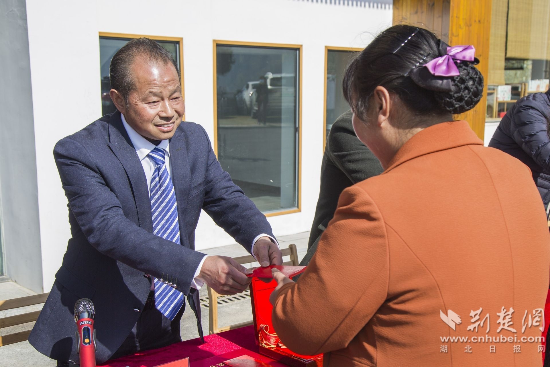 全国脱贫攻坚先进个人、秭归县九畹丝绵茶业有限公司总经理龚万祥为脱贫户和茶叶合作社社员发放分红和红包。（资料图）聂爽 摄.jpg.