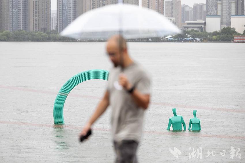武汉发布暴雨红色预警 市民游客雨中散步赏景