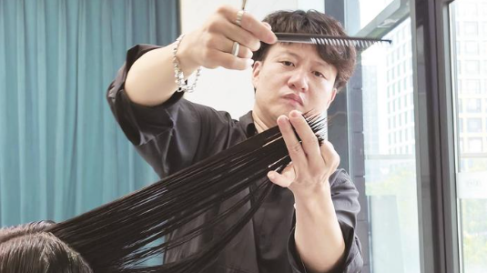“无声理发师”用剪刀精修时光