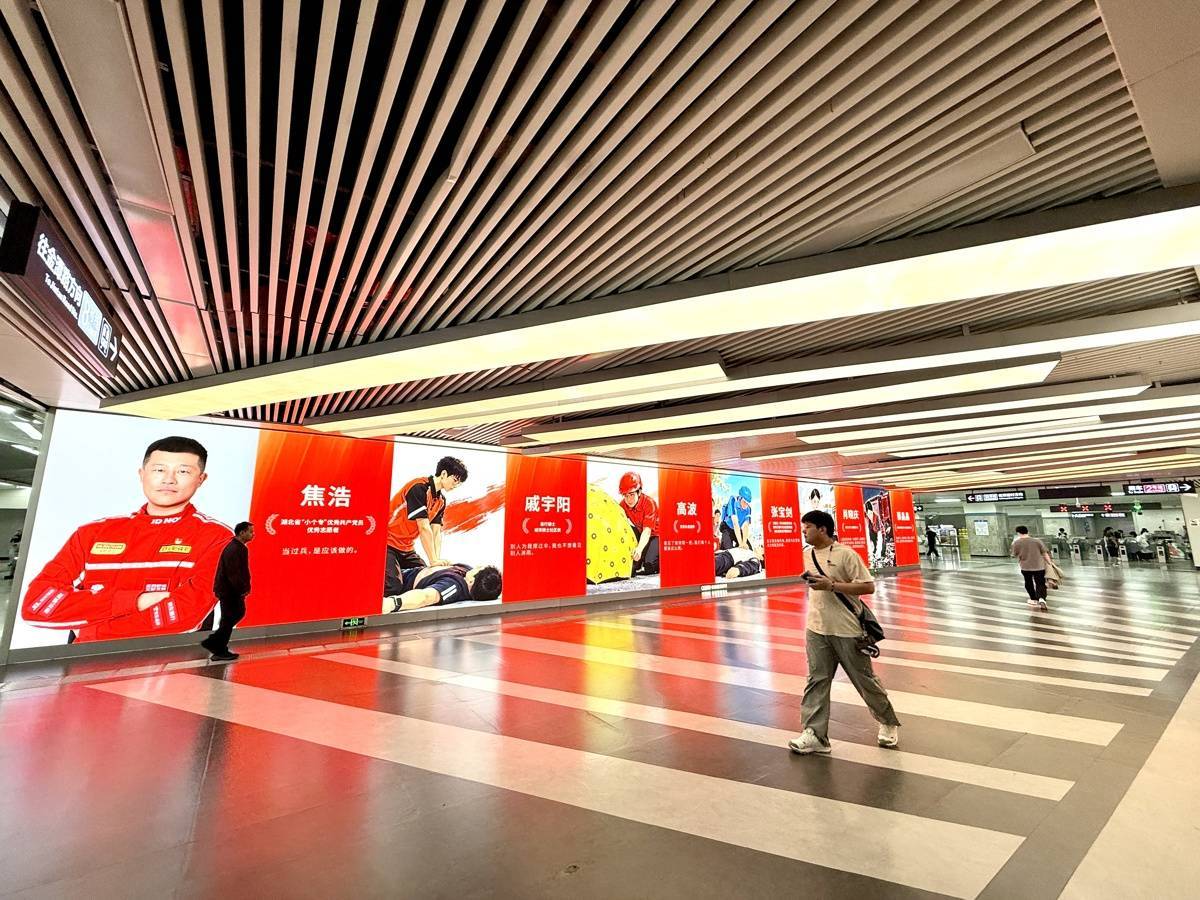 地铁里迎国庆，巨幅国旗与英雄海报点亮江城