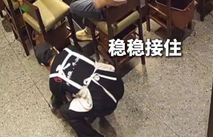 店员小哥稳稳托住险些跌落男孩