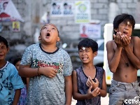 菲律宾庆祝传统节日 儿童脸上挪硬币逗趣十足