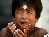 菲律宾庆祝传统节日 儿童脸上挪硬币逗趣十足