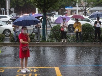 孩子高考，家长在雨中等候