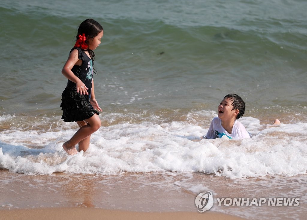 5月28日下午,在釜山海云台海水浴场里,小朋友们在戏水玩耍.